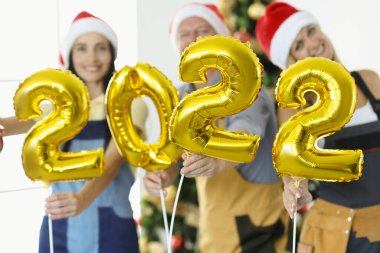 Yeni yıl ağacının arkaplanına karşı 2022 numaralı inşaat ekibi sahip.
