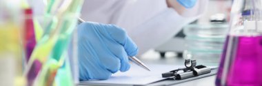 Researcher records data obtained from chemical experiment in laboratory