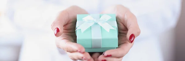 Маленькая бирюзовая подарочная коробка в женских руках крупным планом — стоковое фото
