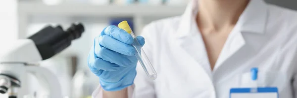 Un scientifique tient une éprouvette vide dans des gants en laboratoire — Photo