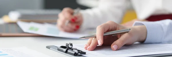 Hands of employees at work table with pen and business documents — Fotografia de Stock