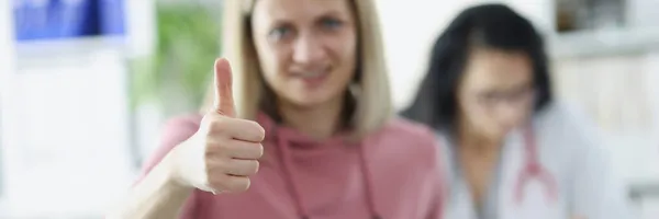 Jonge vrouw patiënt houdt duimen omhoog bij doktersafspraak — Stockfoto