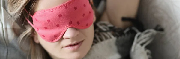 Молодая красивая женщина спит в постели в маске для глаз — стоковое фото