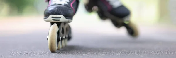 Kind fährt mit schwarzen Rollerblades auf Straße — Stockfoto