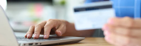 Zakenvrouw houdt credit plastic kaart en wijzerplaten nummer op laptop toetsenbord — Stockfoto