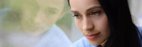 Traurig müde Frau blickt aus Fenster, während es Nahaufnahme regnet — Stockfoto