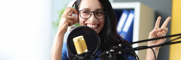 Young radio presenter works in studio, she smiles and broadcasts announcements closeup — Stock Photo, Image