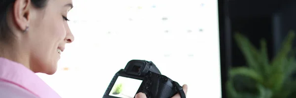 Vrouw houdt camera 's vast en drukt op knoppen op de werkplek close-up — Stockfoto