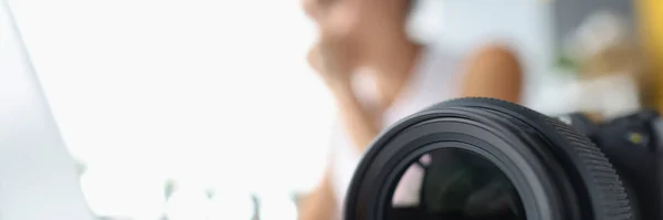 Lente de cámara en el fondo de la mujer que trabaja en el ordenador — Foto de Stock