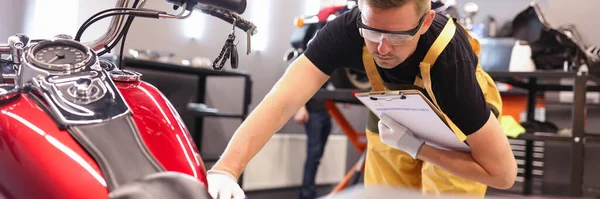남성 자물쇠 제조 업자가 서비스 센터에서 오토바이를 진단하는 모습 — 스톡 사진
