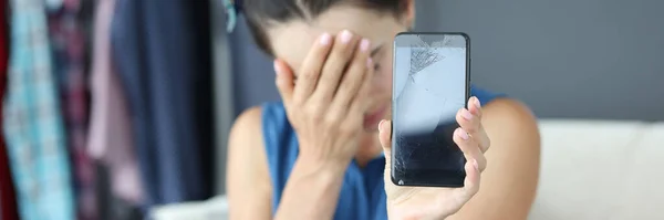 Mulher perturbada segurando um smartphone quebrado close-up — Fotografia de Stock