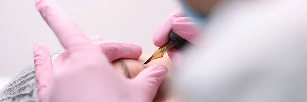 Artista de maquillaje permanente hace flechas para los ojos para el primer plano del cliente — Foto de Stock