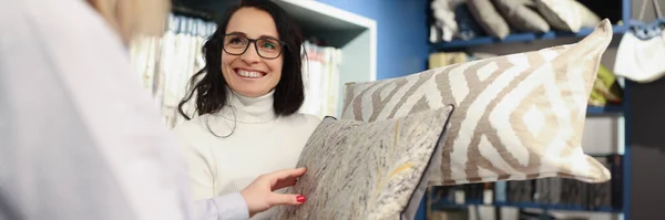 Жінка продавець показує декоративну подушку в салоні — стокове фото