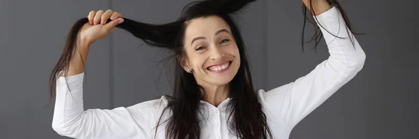 Портрет зрілої жінки, що сміється, тримаючи волосся крупним планом — стокове фото