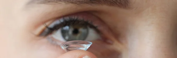 Ung kvinna sätta på kontaktlinser närbild — Stockfoto