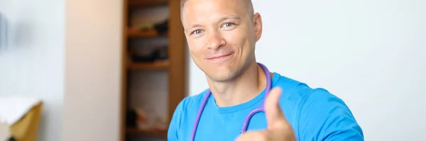 Smiling male doctor making thumbs up gesture — Stock Photo, Image