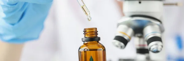 Naukowiec chemik badający olej marihuany pod mikroskopem w laboratorium clo — Zdjęcie stockowe