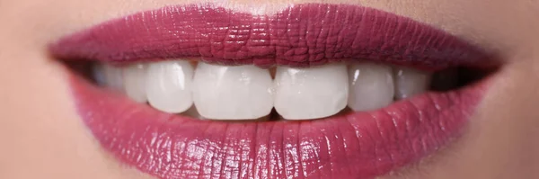 Fechar-se de sorriso de mulher com borgonha lábios pintados com batom — Fotografia de Stock