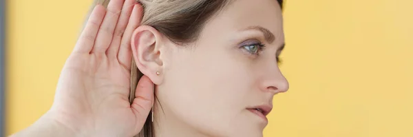 Mujer sordo-muda sosteniendo su mano cerca de la oreja —  Fotos de Stock