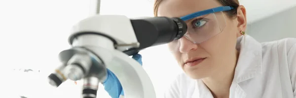Retrato de una científica mirando a través del microscopio en laboratorio — Foto de Stock
