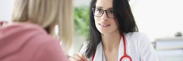 Doctor shows woman patient an X-ray of lungs on tablet closeup — Stock Photo, Image