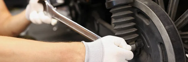 Mekaniker använder skiftnyckel och munstycke för att justera motorcykelns stötdämpare — Stockfoto