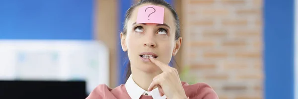 Pensiv kvinna på huvudet med klistermärke med frågetecken — Stockfoto