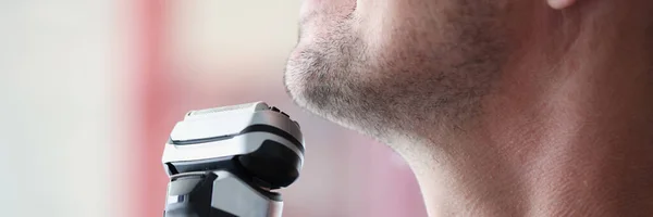Jonge man scheert met elektrisch scheermes close-up — Stockfoto