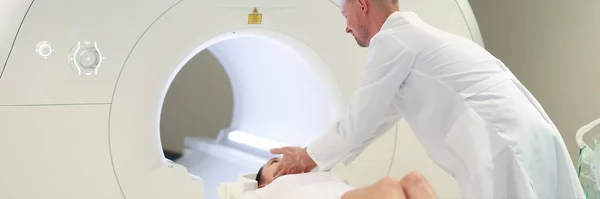 Doktor, kadının klinikteki MRI makinesinde yatmasına yardım ediyor. — Stok fotoğraf