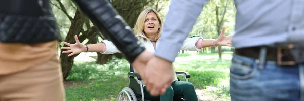 Mulher com deficiência em cadeira de rodas gritando e chorando na frente do casal deixando-a — Fotografia de Stock