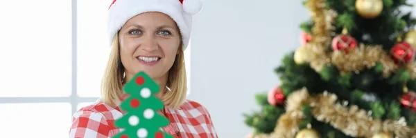 Mulher construtor em santa claus chapéu no fundo da árvore de natal — Fotografia de Stock