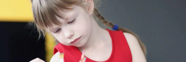 Klein meisje kiezen veelkleurige potloden uit glas — Stockfoto