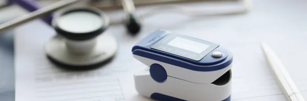Pulsossimetro utilizzato per misurare i livelli di frequenza cardiaca e ossigeno sul tavolo — Foto Stock