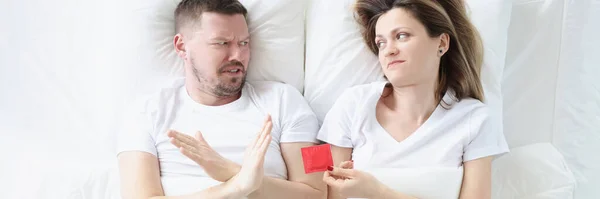 Hombre joven se niega a usar condones mientras está acostado con la mujer en la cama — Foto de Stock