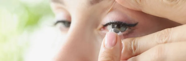 Молодая женщина надевает мягкие контактные линзы на глаз крупным планом — стоковое фото
