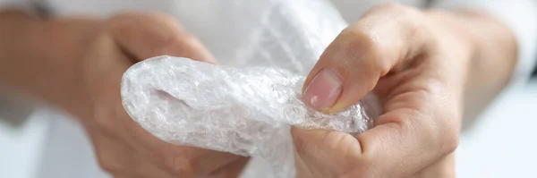 Hembra manos aplastar burbuja bolsa de plástico primer plano —  Fotos de Stock