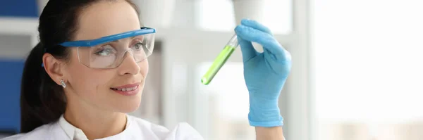 Retrato de científica sonriente con gafas sosteniendo tubo de ensayo químico en laboratorio — Foto de Stock