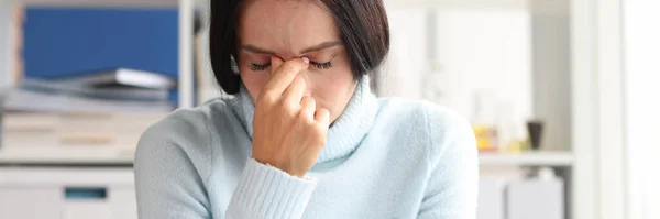 Dolorosa donna depressa siede con gli occhi chiusi sul posto di lavoro — Foto Stock