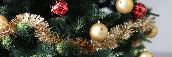 Künstlicher Weihnachtsbaum mit rotgoldenen Kugeln und Lametta geschmückt — Stockfoto