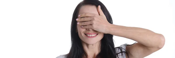 Portret van een jonge glimlachende vrouw die haar ogen bedekt met handclose-up — Stockfoto