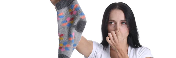 Portrait of young woman covering nose and holding sock in hand closeup — Stock Photo, Image