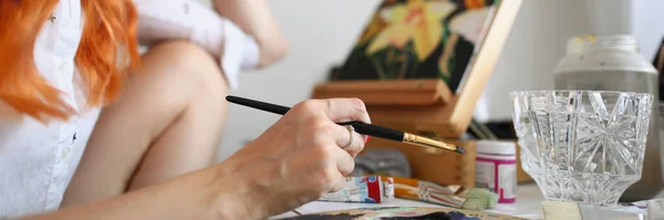 Женщина-художник сидит дома и рисует картину. — стоковое фото