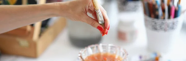 Bir kadın sanatçı boya fırçasından su sıkar. — Stok fotoğraf