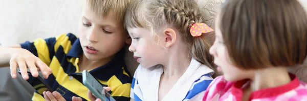 Meisjes en jongen op de bank — Stockfoto