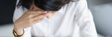 Depresyondaki kadın plastik banka kartlarının ve hesap makinesinin üstüne oturur.