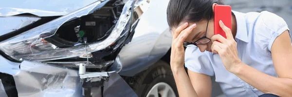 Empörte Frau telefoniert vor dem Hintergrund eines kaputten Autos — Stockfoto