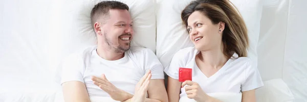 Man weigert te gebruiken condooms terwijl liggend in bed met vrouw — Stockfoto