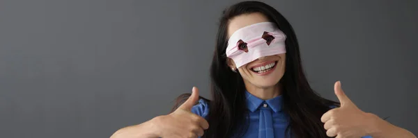 Glimlachende vrouw in masker op gezicht houdt duimen omhoog — Stockfoto