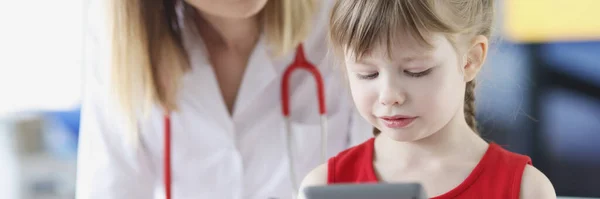 Little beautiful girl at pediatrician is holding calculator closeup — Stock Photo, Image