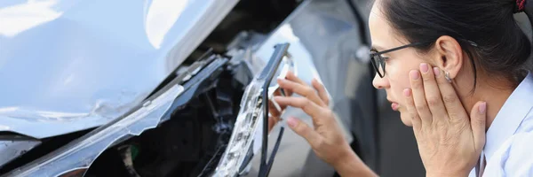 Mujer conductor mira de cerca el coche destrozado —  Fotos de Stock